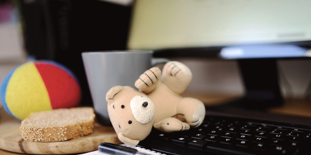 Familienalltag am Laptop mit Spielzeug auf der Tastatur – digitales Chaos im Homeoffice