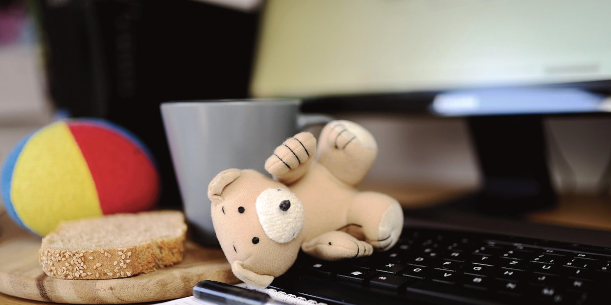 Familienalltag am Laptop mit Spielzeug auf der Tastatur – digitales Chaos im Homeoffice