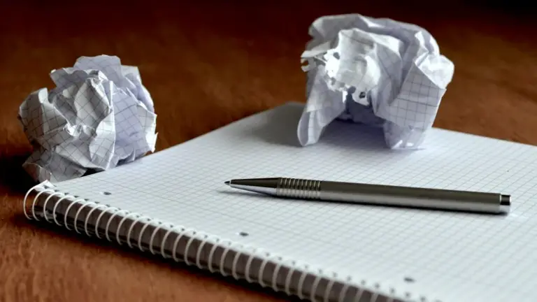 Notizbuch mit Stift und zerknüllten Zetteln als Symbol für das Planen digitaler Ordnung in der Familie