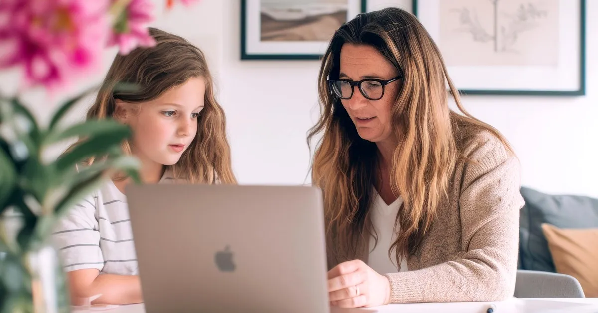 Mutter und Kind organisieren Fotos und Dokumente auf einem Laptop in einer Familien Cloud